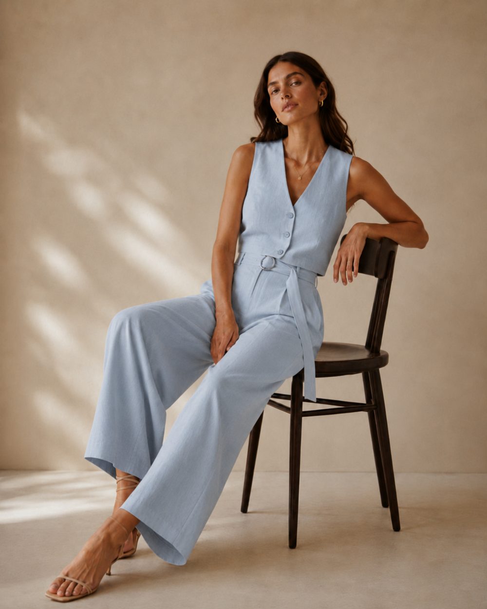 Woman seated on a chair in a pale blue linen set