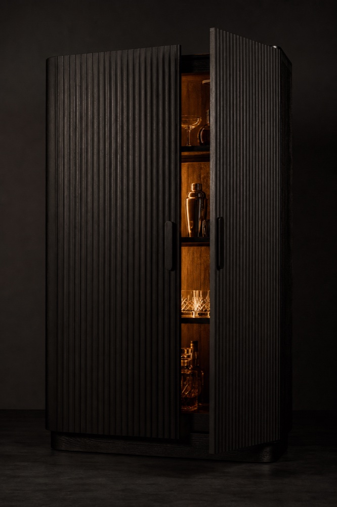 Ribbed black oak bar cabinet glowing from inside