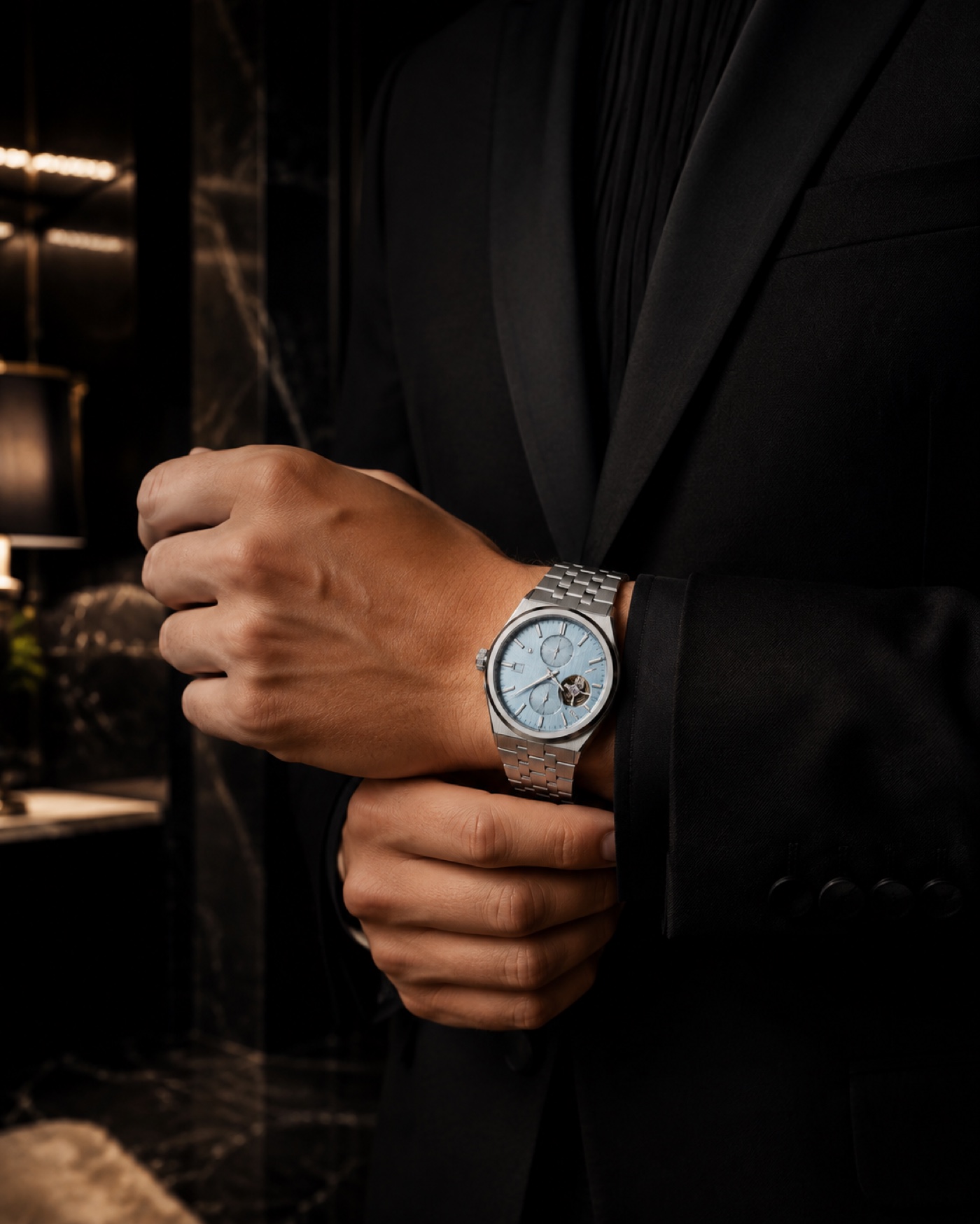 Steel watch worn with a dark suit